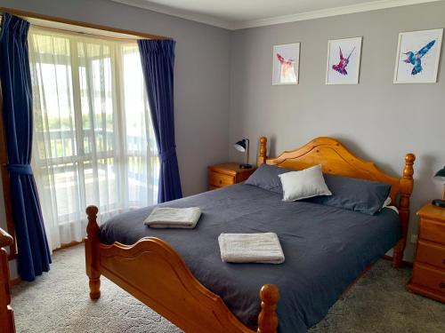 Emu BaySunny Brae的一间卧室配有木床和2条毛巾