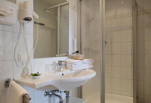 伊尔米茨祖尔索纳旅馆的白色的浴室设有水槽和淋浴。