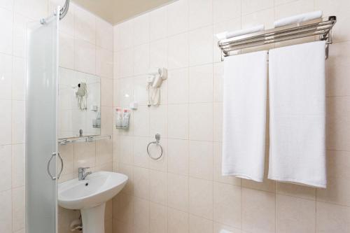 费尔干纳VOYAGE HOTEL的白色的浴室设有水槽和淋浴。