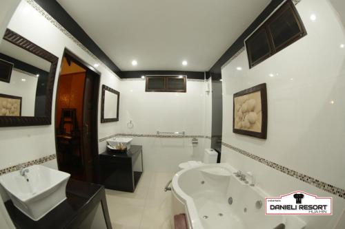华欣达涅利度假村的浴室配有盥洗盆、卫生间和浴缸。