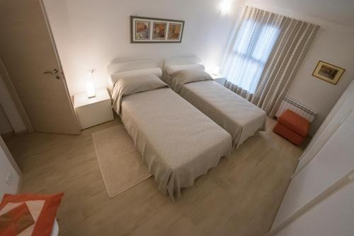 罗维戈ALL'ANTICO CAMPANILE的一间卧室配有一张带白色床单的床和一扇窗户。