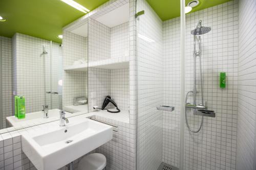 弗莱堡沃邦绿色城市酒店的白色的浴室设有水槽和淋浴。