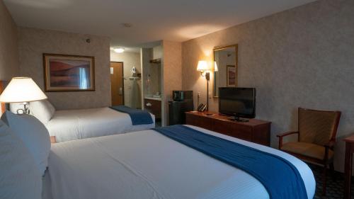 迈尔斯城Miles City Hotel & Suites的酒店客房设有两张床和电视。