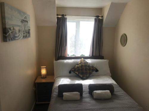 南安普敦Weston Shore的一间卧室配有带两个枕头的床和窗户
