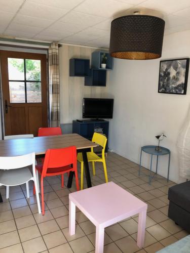 Bernières-sur-MerGITE BORD DE MER的一间配备有桌子和五颜六色椅子的用餐室