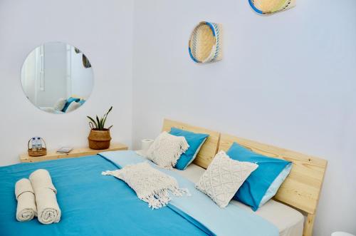 普拉亚Casa Sodadi的一张带蓝色和白色枕头及镜子的床