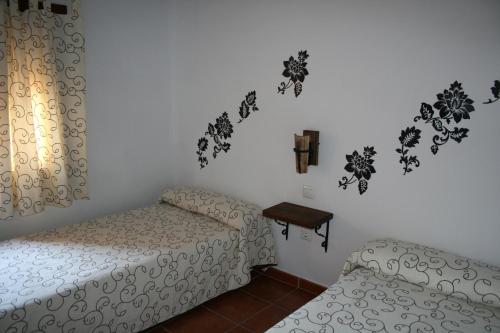 Villarrubia de Santiago卡萨农村拉波萨达德尔弗朗西丝乡村民宿的卧室配有两张床和一张墙上的桌子。