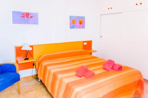 福尔内利斯SOL NAIXENT的一间卧室配有一张床,上面有2个粉红色的拖鞋