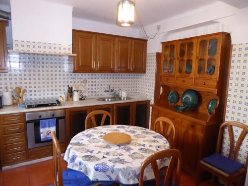 米尔芳提斯城CASA BERIMBAU的厨房配有桌子、水槽和桌椅