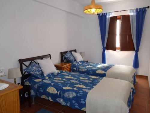 米尔芳提斯城CASA BERIMBAU的一间卧室设有两张床、一张桌子和一个窗口
