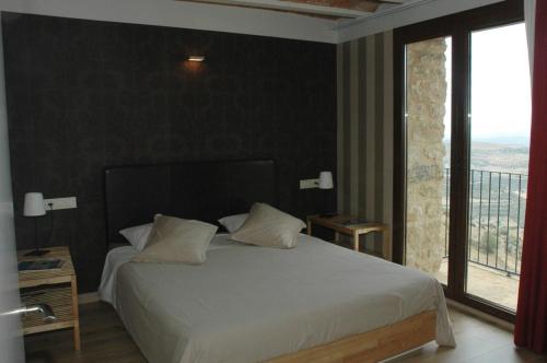 Ares del MaestreCasa Rural Virginia的卧室设有白色的床和大窗户