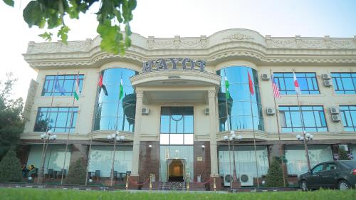 塔什干Hayot Hotel的前面有旗帜的大建筑
