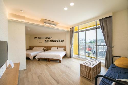 小琉球岛小火鸡旅店的一间带两张床的卧室和一个阳台