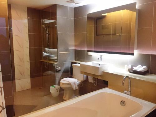 彭世洛和谐城市酒店的带浴缸、盥洗盆和卫生间的浴室
