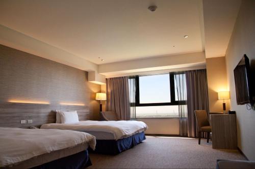大园区桃禧航空城酒店-新馆的酒店客房设有两张床和窗户。