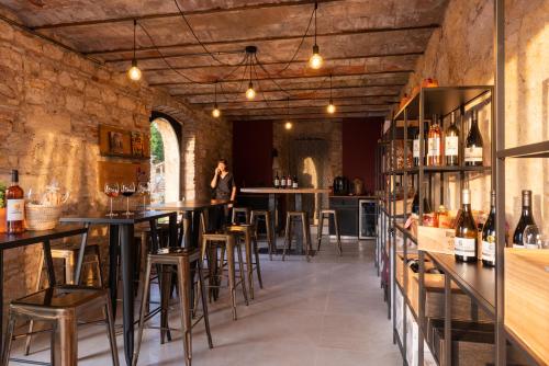 盖亚克Château de Tauzies, The Originals Relais的大楼内带桌子和酒吧凳的酒吧