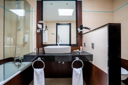卡门港拉斯科斯塔斯酒店的浴室配有盥洗盆、镜子和浴缸