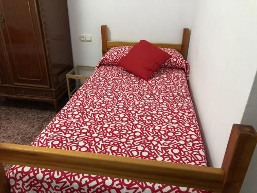 阿尔戈多纳莱斯Casa Antonio Algodonales的床上有红色枕头