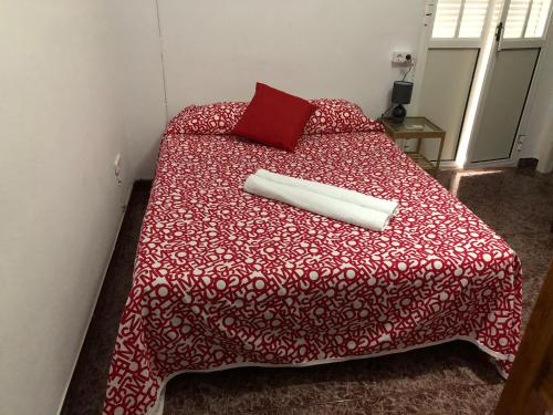 阿尔戈多纳莱斯Casa Antonio Algodonales的一张带红色棉被的床和枕头