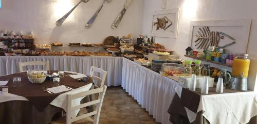 圣特雷莎加卢拉卡恩文托酒店的一间设有两张桌子的餐厅和一个提供食物的柜台