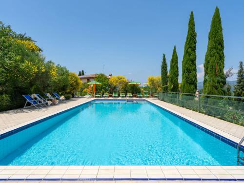 蒙泰卢波菲奥伦蒂诺Villa La Rosa by Interhome的一座拥有蓝色海水和树木的大型游泳池