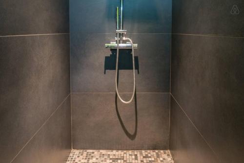 拉西约塔Chambre d'hôtes LE SECADOU的一间带淋浴的浴室,墙上装有软管