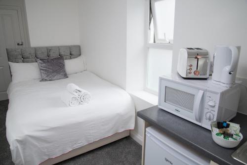 贝肯翰姆TLK Apartments & Hotel - Beckenham的一间带床和电视的小卧室