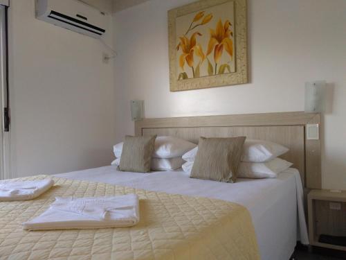 弗洛里亚诺波利斯Brava Apart Hotel的一间卧室配有两张带毛巾的床