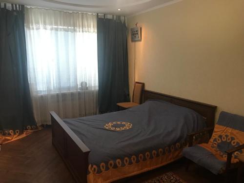 蒂拉斯波尔Квартира в Тирасполе的一间卧室配有床和带窗帘的窗户
