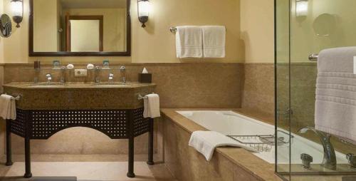 沙姆沙伊赫Elegant Apartment in a Luxury Resort的一间带水槽、浴缸和镜子的浴室