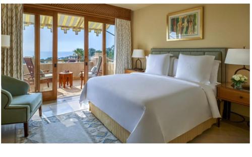 沙姆沙伊赫Elegant Apartment in a Luxury Resort的一间带一张白色大床的卧室和一个阳台