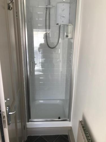 北安普敦老屠夫公寓的浴室里设有玻璃门淋浴