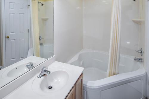 布兰森福尔溪钻石度假村套房酒店的白色的浴室设有水槽和淋浴。