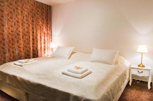 马汀VILLA CENTRUM APARTMÁNY s RAŇAJKAMI A SAUNOU的一间卧室配有带毛巾的床