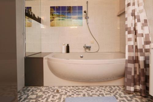 尼科西亚The Bridge-House Apartment的带淋浴的浴室内的白色浴缸