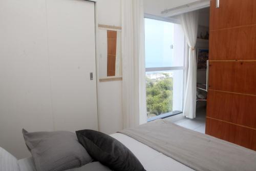 萨尔瓦多Encantos do Porto da Barra的一间卧室设有一张床和一个大窗户