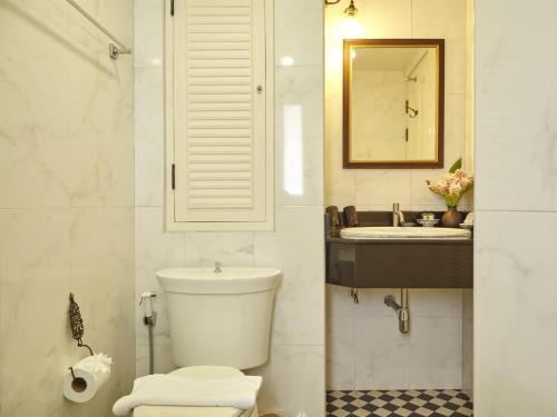 曼谷SSIP Boutique Dhevej Bangkok的一间带卫生间、水槽和镜子的浴室
