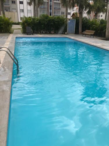 圣地亚哥洛斯卡巴CONFORTABLE first floor en santiago RD的大楼里的一个大型蓝色游泳池