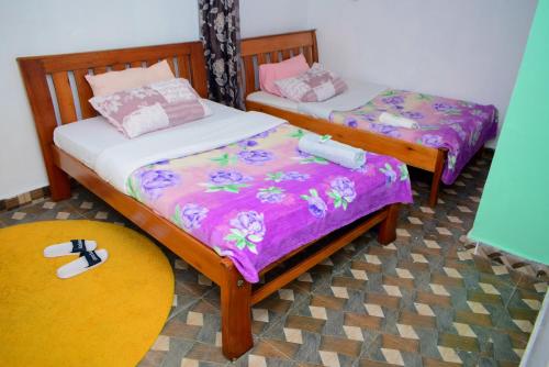 内罗毕Kenya Inn的配有两张单人床的客房,铺有地毯