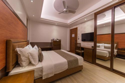 胡鲁马累Samann Host的酒店客房,配有床和电视