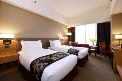 花莲市福容大饭店的酒店客房配有两张床和一张书桌