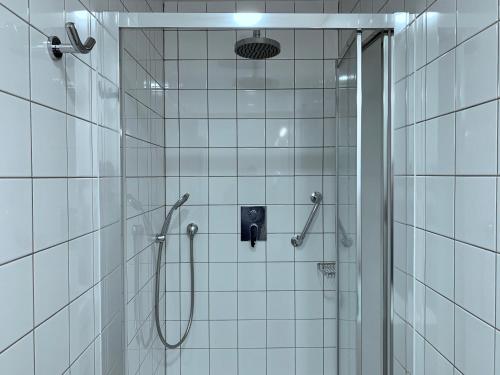 玛丽亚温泉Marienbad Apartment的浴室铺有白色瓷砖,设有淋浴。