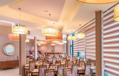 克卢日-纳波卡西城酒店的一间带桌子和吊灯的用餐室