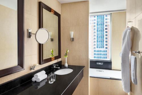 迪拜香格里拉公寓酒店的一间带水槽和镜子的浴室以及窗户。