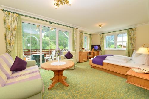 米特尔贝格Hotel Garni Ingeborg的一间卧室配有一张床、一张沙发和一张桌子