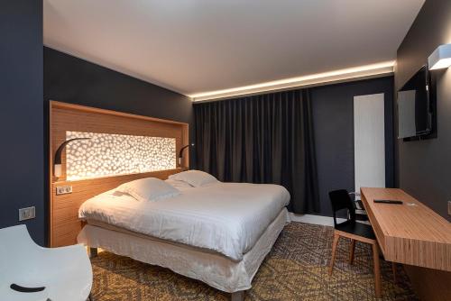 伊斯术Hôtel Restaurant Au Cygne的配有一张床和一张书桌的酒店客房