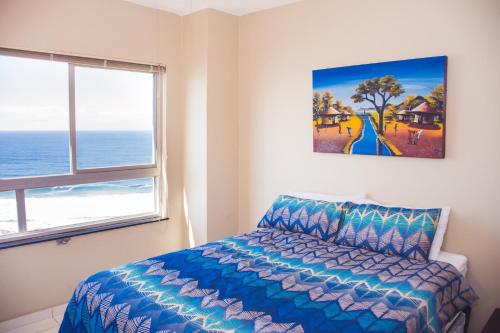 阿曼济姆托蒂High Tide的卧室配有一张床,墙上挂有绘画作品