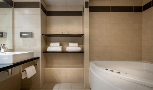 蒙蒂约总督庄园酒店、餐厅及高尔夫球场的浴室配有水槽、浴缸和毛巾