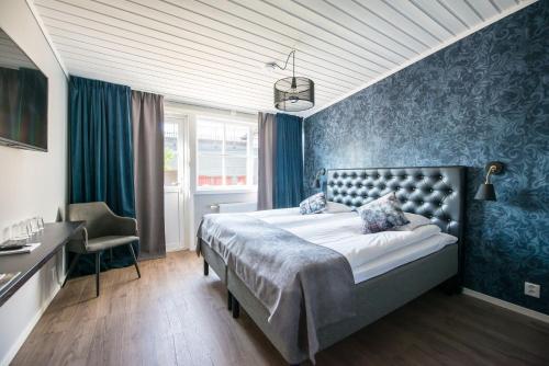 博伦厄Gylle Hotell & Restaurang Brödernas的一间卧室配有一张床、一张桌子和一把椅子