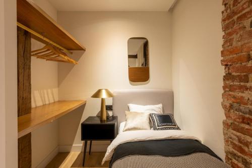 毕尔巴鄂Safari AC by Staynnapartments的一间卧室设有一张床和砖墙